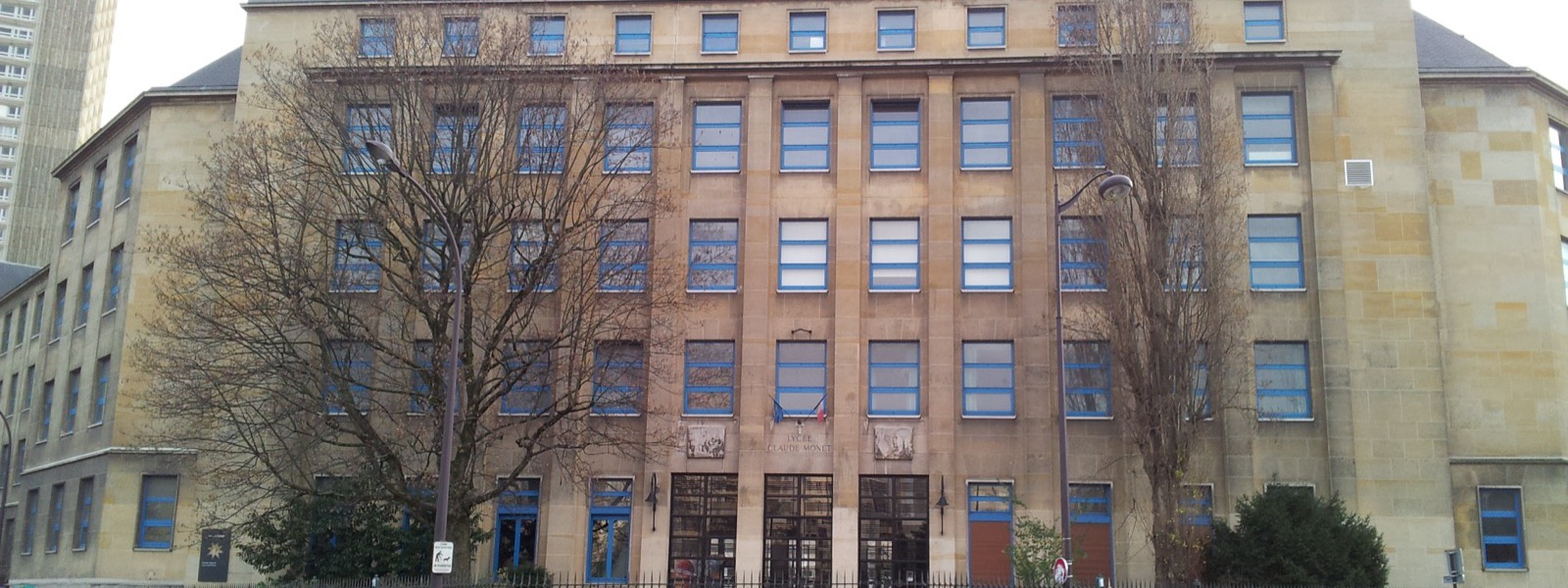 Façade en pierre du lycée Claude-Monet, rue du Docteur-Magnan, avec ses fenêtres bleues